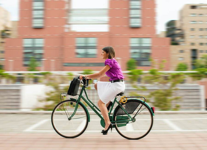 women riding into work on a bike